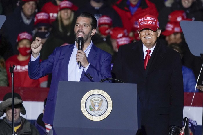 FILE - In this Nov. 2, 2020, file photo President Donald Trump watches as Donald Trump Jr. speaks at a campaign event at the Kenosha Regional Airport in Kenosha, Wis. A spokesman says President Donald Trump’s eldest son, Donald Trump Jr., has been infected with the coronavirus.  The spokesman says the younger Trump learned his diagnosis earlier this week, has no symptoms and has been quarantining. (AP Photo/Morry Gash, File)