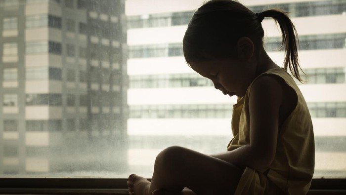 Ilustrasi balita A litte girl sitting next to a window with her head down in sadness. Feeling depressed and hurt.