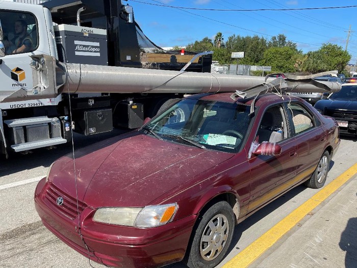 In this photo provided by the Florida Highway Patrol a downed power pole is strapped to the roof of a car, Monday, Nov. 16, 2020, on Interstate 4, in Hillsborough County, Fla. A state trooper pulled over a maroon Toyota Camry with a metal light pole, longer than the car itself, strapped to the roof on a Tampa road Monday morning, according to a Florida Highway Patrol report. The Camrys driver, Douglas Allen Hatley, told troopers that he had found the pole on the ground by the side of the highway and had planned to sell the metal for scrap, according to the report.   Hatley charged with grand theft was being held on $2,000 bond. (Florida Highway Patrol via AP)