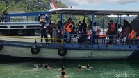 Ketika kapal menepi, terlihat beberapa bocah berenang dengan asyik. Kami pun melemparkan koin ke air untuk mereka ambil. 