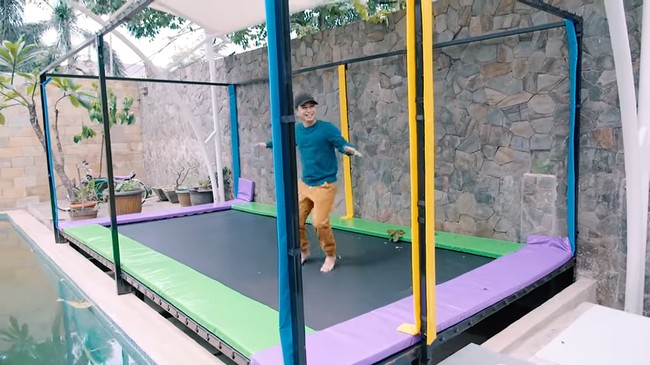 Hampir sama seperti Zaskia, Ria Ricis juga memiliki sebuah trampolin di dekat area kolam renangnya. Jika dilihat trampolin milik Ria Ricis cukup besar ya, bikin serasa di mal. Foto: YouTube/Raditya Dika