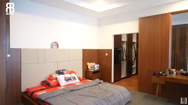 Nuansa kayu-kayuan yang hangat juga muncul di area kamar utama. Tampak area kamar dilengkapi sebuah walk-in closet yang mungil. (Foto: YouTube/Rizky Billar)
