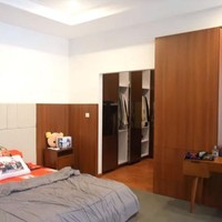 Nuansa kayu-kayuan yang hangat juga muncul di area kamar utama. Tampak area kamar dilengkapi sebuah walk-in closet yang mungil. (Foto: YouTube/Rizky Billar)