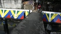Seorang warga melintasi kawasan Kali Utan Kayu yang berada di Matraman, Jakarta Timur.