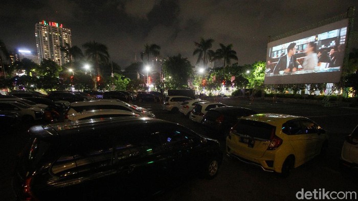 Pengunjung menyaksikan pemutaran film dari dalam mobil (drive-in) di area parkir Grand City, Surabaya, Jawa Timur, Kamis (19/11/2020). Pemutaran film yang berlangsung hingga 29 November tersebut menjadi alternatif hiburan bagi masyarakat Kota Surabaya di tengah pandemi COVID-19. ANTARA FOTO/Moch Asim/
