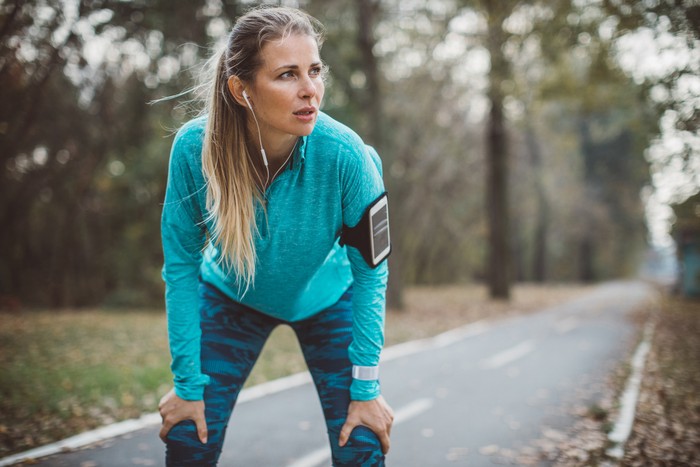 Adult running women exercise outdoor. She is exhausted after hard training, portrait