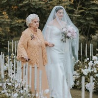 Upacara pernikahan terlihat diadakan di area terbuka atau outdoor. Suasana tampak indah dengan dekorasi mawar putih kreasi Yu Cien Lotus Design. Foto: Instagram/@sumargodeny