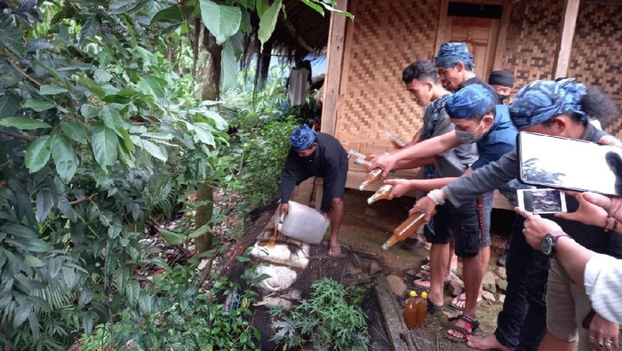 Sejumlah warga memusnahkan madu palsu.