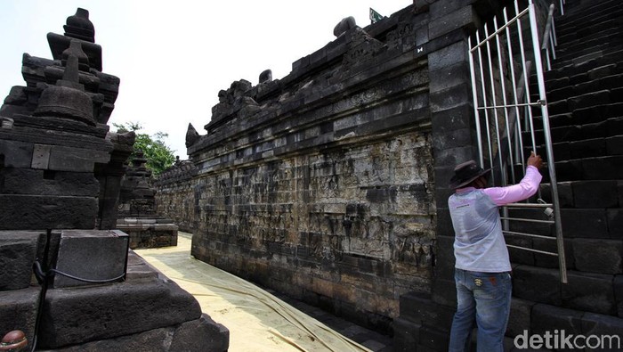 Pekerja menyelimuti stupa dengan terpal di kawasan Candi Borobudur, Magelang, Jawa Tengah, Senin (23/11). Selain penutupan stupa yang sudah berlangsung 3 minggu pihak balai Konservasi Candi Borobudur hanya membuka taman Candi Borobudur untuk umum dan pengunjung dilarang menaiki candi  selama pandemi ini hanya dihalaman candi.
