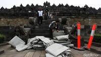 Petugas menyiapkan terpal yang akan digunakan untuk menutupi stupa Borobudur.
