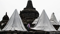 Petugas menutupi stupa candi Borobudur dengan terpal, Senin (23/11).