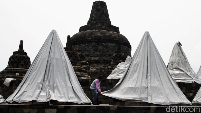 Pekerja menyelimuti stupa dengan terpal di kawasan Candi Borobudur, Magelang, Jawa Tengah, Senin (23/11). Selain penutupan stupa yang sudah berlangsung 3 minggu pihak balai Konservasi Candi Borobudur hanya membuka taman Candi Borobudur untuk umum dan pengunjung dilarang menaiki candi  selama pandemi ini hanya dihalaman candi.
