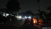 Sejumlah warga berjaga di depan rumah di dusun Stabelan, Tlogolele, Boyolali, Jawa Tengah, Minggu (22/11/2020) malam. 
