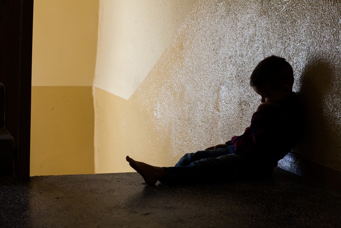 eye of boy through key whole, child abuse concept