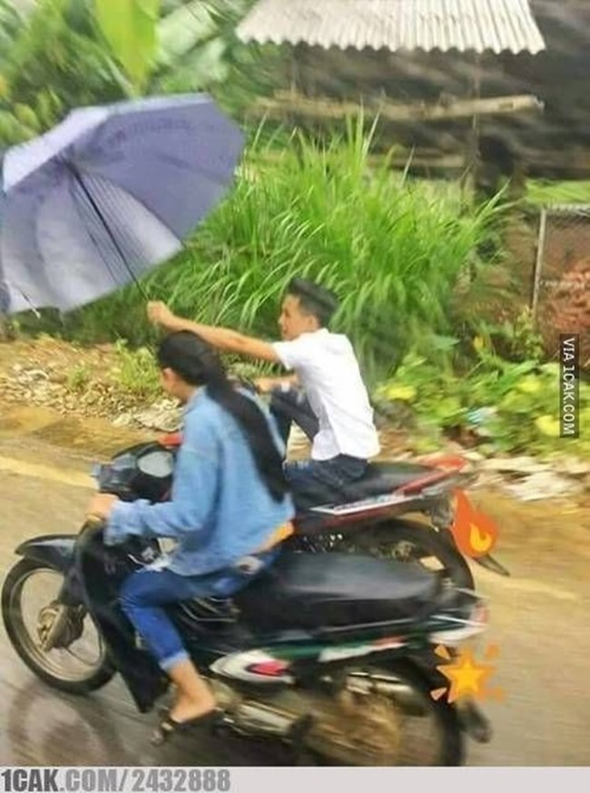 Maksudnya sih biar romantis kali ya, makanya si cowok sampe rela megangin payung sambil naik motor gitu. Padahal kan bisa pakai jas hujan aja ya biar nggak ribet.. Foto: 1cak.com