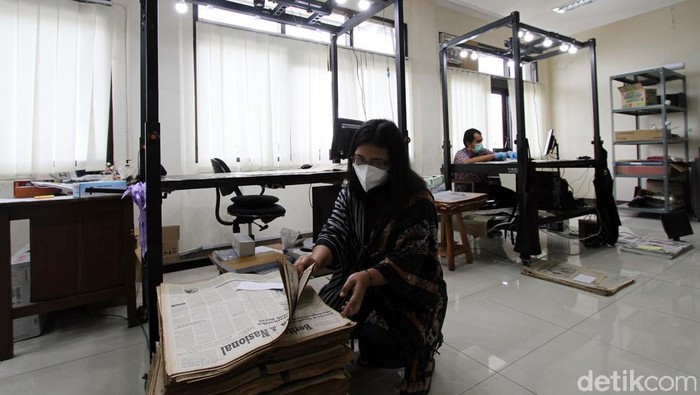 Mengintip Proses Digitalisasi Koran Cetak Pekerja memotret kertas koran dari tahun 50an hingga 2000 awal untuk dialih digitalkan di Monumen Pers, Solo, Jawa Tengah, Selasa (24/11). Setiap harinya mereka mampu mneyelesaikan sekitar 80 koran cetak atau sekitar 700 an lembar untuk digunakan sebagai dokumentasi alih media serta edukasi.