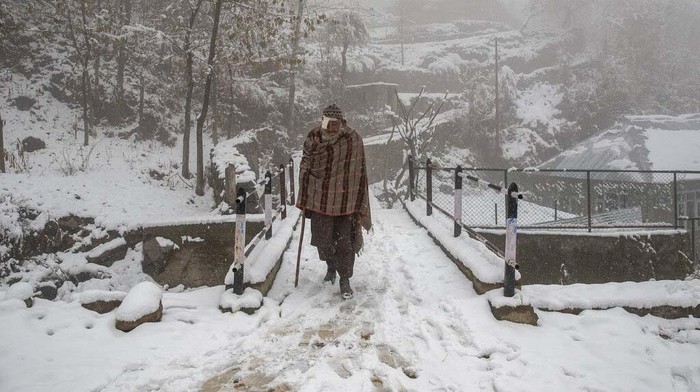 Potret Hujan Salju di Kashmir Kashmir villagers walk on a snow covered road during the season's first snowfall on the outskirts of Srinagar, Indian controlled Kashmir, Monday, Nov. 23, 2020. (AP Photo/Dar Yasin)