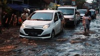 Buruh yang bekerja di kawasan industri di Jalan Sukabirus, Kecamatan Dayeuhkolot menerobos genangan banjir.