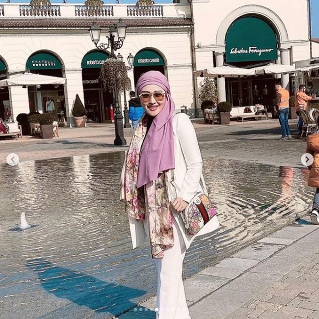 Pada kesempatan lainnya saat berada di luar negeri, Iis Rosita Dewi berpose memakai scarf motif bunga dan tas dari brand high end Gucci yang motifnya senada.  Foto: Instagram @ iisedhyprabowo