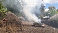 Pelataran kampung Suku Dani dengan rumah honainya. Di tengahnya ada tempat pembakaran.