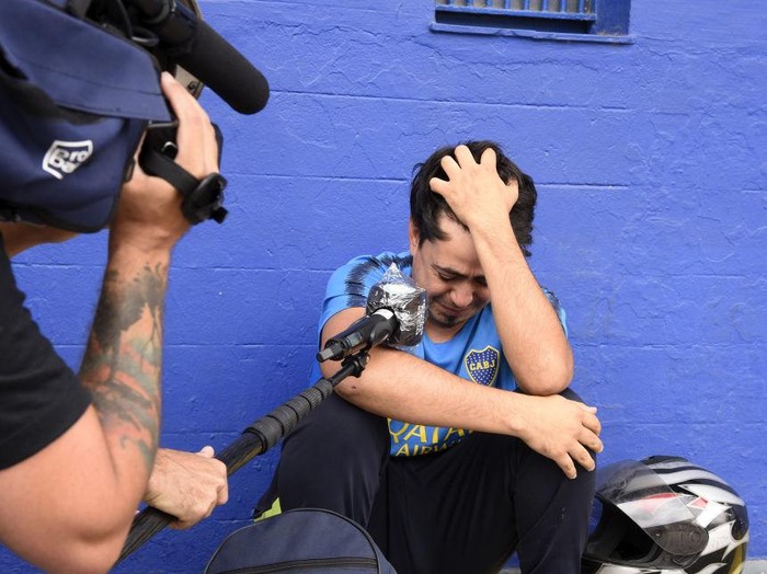 BUENOS AIRES, ARGENTINA - NOVEMBER 25: A fan cries as he is interviewed near La Bombonera stadium after the news of the death of Diego Maradona was known on November 25, 2020 in Buenos Aires. Diego Maradona, considered one of the biggest football stars in history, died at 60 from a heart attack on Wednesday in Buenos Aires.  (Photo by Fotonoticias/Getty Images)
