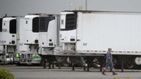 Truk-truk, yang jumlahnya diperkirakan 50 buah, tersebut dimodifikasi menjadi kamar mayat darurat ketika fasilitas kamar mayat di rumah sakit dan rumah duka dipenuhi kala itu. Spencer Platt/Getty Images/AFP