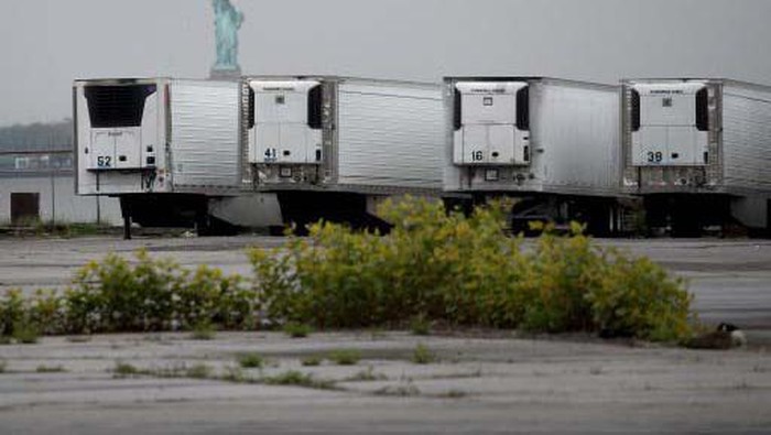 NEW YORK, NEW YORK - NOVEMBER 23: Refrigerated morgue trailers believed to be holding the bodies of people who died of COVID-19 are seen at South Brooklyn Marine Terminal on November 23, 2020 in New York City. According to recent reports, it is estimated that about 650 bodies are being stored in the trailers at a temporary emergency morgue that was set up in April until funeral homes or crematories can accept them. Many early COVID-19 victims that are being stored are from families who can’t be located or are not able to afford a burial.   Spencer Platt/Getty Images/AFP
