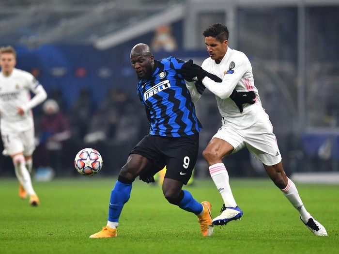 MILAN, ITALY - NOVEMBER 25: Romelu Lukaku of Inter Milan is challenged by Raphael Varane of Real Madrid during the UEFA Champions League Group B stage match between FC Internazionale and Real Madrid at Stadio Giuseppe Meazza on November 25, 2020 in Milan, Italy. Football Stadiums around Europe remain empty due to the Coronavirus Pandemic as Government social distancing laws prohibit fans inside venues resulting in fixtures being played behind closed doors. (Photo by Valerio Pennicino/Getty Images)