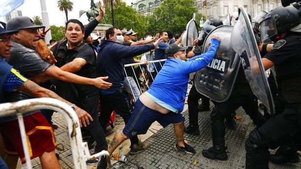 Warga tumpah ruah memadati halaman Istana Presiden Argentina. Kedatangan mereka untuk berikan penghormatan terakhir bagi Maradona yang disemayamkan di sana.