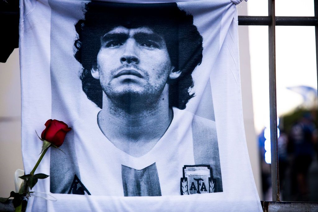 Diego Maradona BUENOS AIRES, ARGENTINA - NOVEMBER 26: A shirt with the image of former football star Diego Maradona hangs on a fence on November 26, 2020 in Buenos Aires, Argentina. Diego Maradona, considered one of the biggest football stars in history, died at 60 from a heart attack on Wednesday in Buenos Aires. (Photo by Tomas Cuesta/Getty Images)