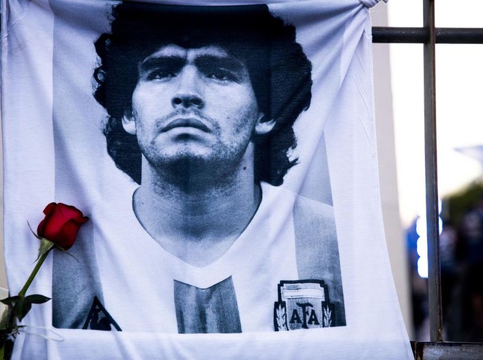 BUENOS AIRES, ARGENTINA - NOVEMBER 26: A shirt with the image of former football star Diego Maradona hangs on a fence on November 26, 2020 in Buenos Aires, Argentina. Diego Maradona, considered one of the biggest football stars in history, died at 60 from a heart attack on Wednesday in Buenos Aires.  (Photo by Tomas Cuesta/Getty Images)