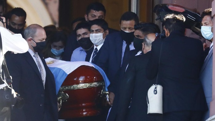 Police detain a soccer fan at Plaza de Mayo, where mourners are lining up to see the casket with the remains of Diego Maradona lying in state inside the presidential palace, in Buenos Aires, Argentina, Thursday, Nov. 26, 2020. The Argentine soccer great who was among the best players ever and who led his country to the 1986 World Cup title died from a heart attack at his home Wednesday, at the age of 60. (AP Photo/Rodrigo Abd)