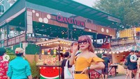 Nah kalau ini gaya modis Eva saat jalan-jalan dan berpose di area festival penuh makanan. Foto: Instagram @evabelisima_official