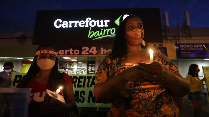 Gelombang Unjuk Rasa Black Lives Matter di Brasil A Black Lives Matter activist wearing traditional African clothes, lights a candle during a vigil to protest the murder by security guards of Joao Albert Silveira Freitas after he broke into the Carrefour supermarket, in Brasilia, Brazil, Thursday, Nov 26, 2020. Joao Alberto Silveira Freitas died after being beaten by supermarket security guards in the southern Brazilian city of Porto Alegre on the eve of Friday's Black Consciousness Day observations, sparking outrage as videos of the incident circulated on social media. (AP Photo/Eraldo Peres)