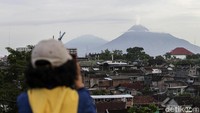 Warga mengabadikan asap sulfatara yang disemburkan oleh Gunung Merapi.