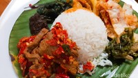 Satu porsi nasi Kapau di sini disajikan dengan sayur Kapau (gulai nangka), tumisan daun singkong, bumbu rendang, sambal ijo, dan keripik singkong balado. Foto: detikFood/Yenny Mustika Sari