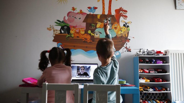 Sofia Roboli records sign language lessons that are broadcast on public television, at an elementary school in Athens, Friday, Nov. 20, 2020. Most other European countries have vowed to keep schools open, but the pandemic has hit Greece hard for the first time in recent weeks following a successful lockdown in the spring, overwhelming hospitals in parts of the country. State television is making and broadcasting lessons, while teachers sit in empty classrooms talking to remote students. Despite some problems, they say it keeps children in touch with their schools. (AP Photo/Thanassis Stavrakis)