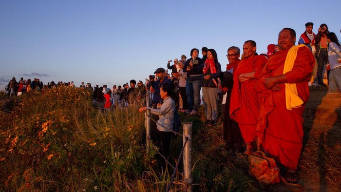 Tourists gather at a mountain viewpoint as sun rises over mist covered Laotian villages seen from Phu Chi Fa viewpoint, Chiang Rai, Thailand Friday, Nov. 27, 2020. Domestic tourists have taken advantage of promotions announced by the Thai Government to boost the domestic tourism sector impacted by COVID-19 travel restrictions. (AP Photo/Gemunu Amarasinghe)