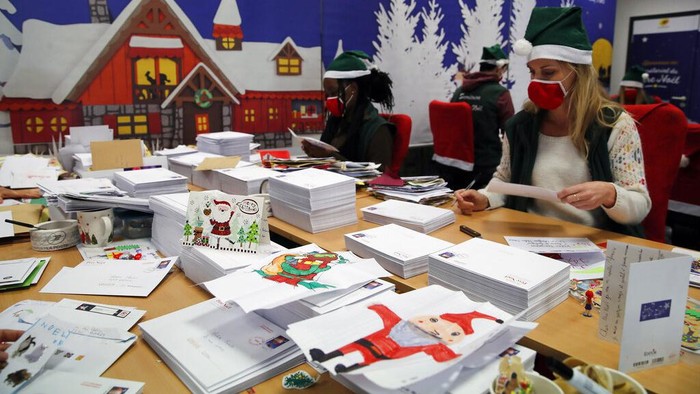 Potret Puluhan Ribu Surat Natal dari Anak-anak Prancis A postal worker shows an envelope from Jim of Taiwan, who sent a face mask inside the letter he sent and wrote