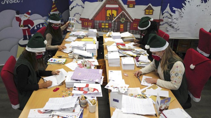 Potret Puluhan Ribu Surat Natal dari Anak-anak Prancis A postal worker shows an envelope from Jim of Taiwan, who sent a face mask inside the letter he sent and wrote
