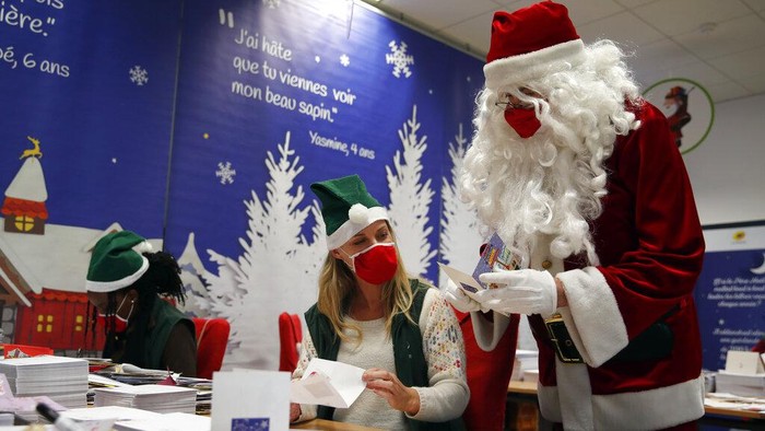 Potret Puluhan Ribu Surat Natal dari Anak-anak Prancis A postal worker shows an envelope from Jim of Taiwan, who sent a face mask inside the letter he sent and wrote