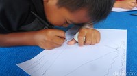 Anak-anak menggambar beragam objek dan tulisan ke setiap kertas yang dibagikan.
