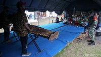 Hiburan musik angklung dapat mengobati rasa bosan dan jenuh para pengungsi yang sudah tiga pekan tinggal di barak pengungsian.