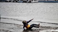 Seorang warga asyik bermain banjir rob.