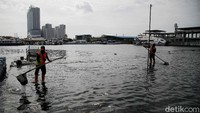 Banjir rob membawa sampah plastik ke pinggir pantai.