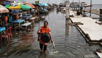 Sejumlah pedagang beraktivitas di kawasan Pelabuhan Kali Adem yang terendam air rob.