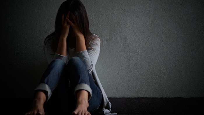 sedih sad woman hug her knee and cry. Sad woman sitting alone in a empty room.