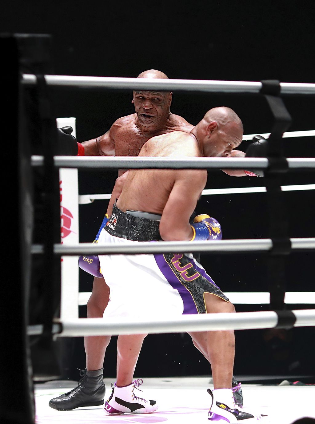 In a photo provided by Triller, Mike Tyson throws a punch during the fourth round against Roy Jones Jr. in an exhibition boxing bout Saturday, Nov. 28, 2020, in Los Angeles. The bout was unofficially ruled a draw by the WBC judges at ringside. Tyson and Jones fought eight two-minute rounds, and both emerged smiling and apparently healthy from a highly unusual event. (Joe Scarnici/Triller via AP)