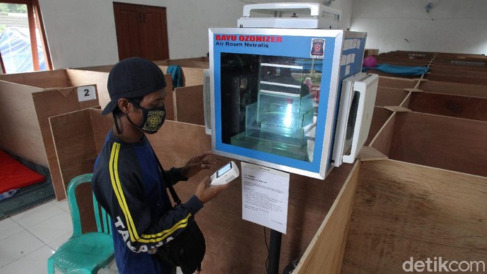 Anggota Tagana menunjukkan alat pembersih udara yang dipasang di Barak Pengungsian Glagaharjo, Sleman, Yogyakarta, Senin (30/11/2020). Alat pembersih udara tersebut berfungsi untuk mencegah persebaran COVID-19 melalui udara diruangan pengungsian.