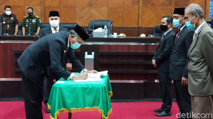 Gubernur Aceh Nova Iriansyah saat meneken berita acara persetujuan bersama terhadap Rancangan Qanun Aceh Tentang APBA 2021. (Agus Setyadi/detikcom).
